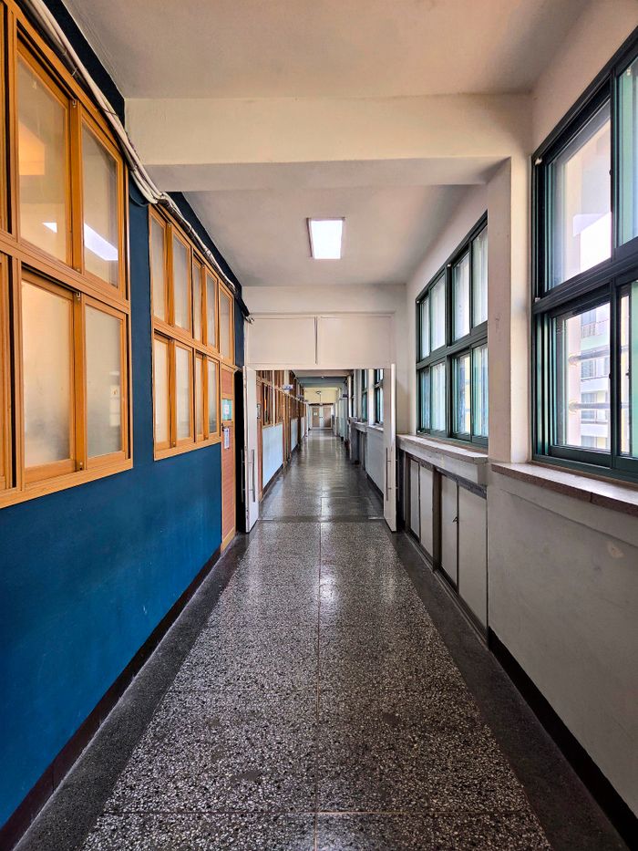 Wide-angle view of an empty school corridor in Seoul, featuring modern architecture.
